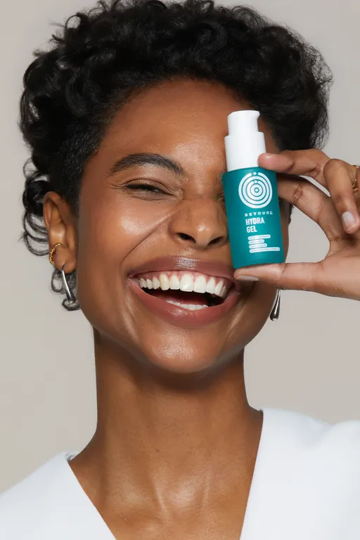Creator sorrindo com o sérum da Beyoung